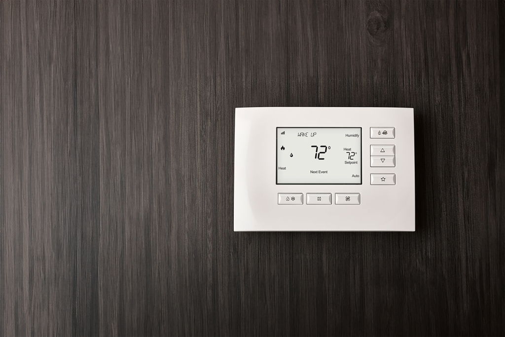 smart thermostat mounted on a wooden wall