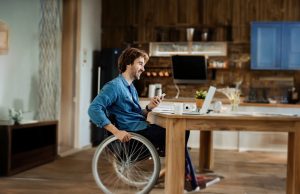 man in wheel chair on his phone interacting with smart home system